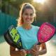 Joueur de padel débutant tenant plusieurs rackets colorés en extérieur